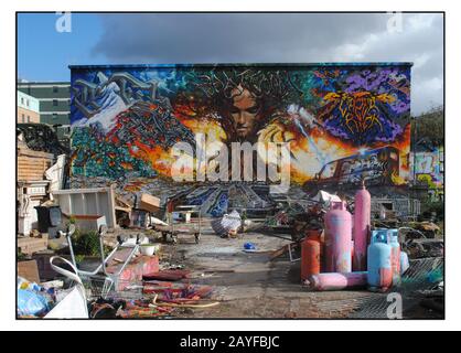 IM GESCHLOSSENEN NOMADISCHEN GEMEINSCHAFTSGARTEN, SHOREDITCH, MIT EINEM GROSSEN WANDGEMÄLDE AN DER EX-VIADUKTWAND. Stockfoto