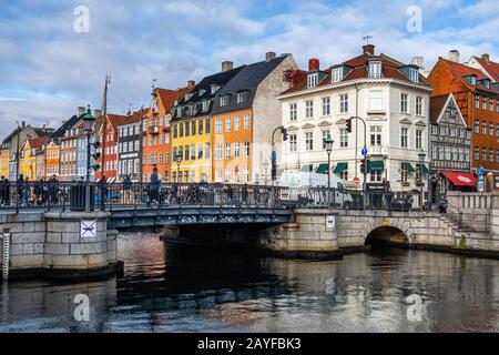 Nyhavn Canal mit bunten Gebäuden, alten pastellfarbenen Stadthäusern, Restaurants, Cafés und angedockten Booten im Zentrum von Kopenhagen, Dänemark Stockfoto