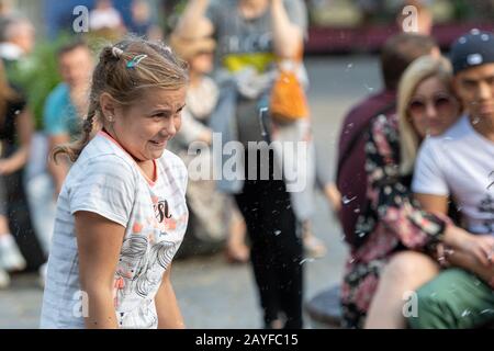 Altstädter Ring, Riga, Lettland - 16. August 2019: Kinder, die mit bunten Seifenblasen spielen, schweben im Vordergrund Stockfoto