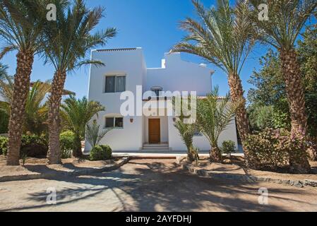 Luxuriöse Villa mit Blick auf die Außenansicht des Hauses in einem tropischen Resort mit Palmen und Garten Stockfoto