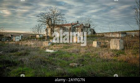 Verlassene Kirchenruine und Friedhofsüberwucherte Landschaft Verloren Orte Stockfoto