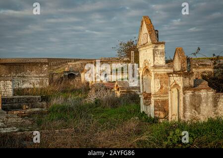 Verlassener Ruinenfriedhof und überwucherte Landschaft Natur Verloren Orte Stockfoto