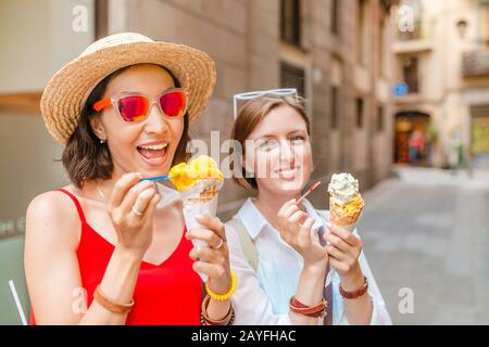 Zwei Freundinnen haben Spaß und essen Eis Stockfoto