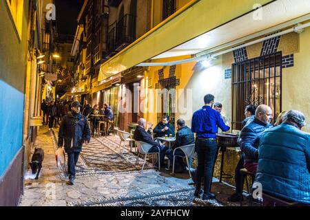 Nachtleben in Granada, einer Stadt im südspanischen Andalusien. Nachts lebhaft mit vielen Tapas-Bars und Restaurants im Freien auf dem Bürgersteig. Stockfoto