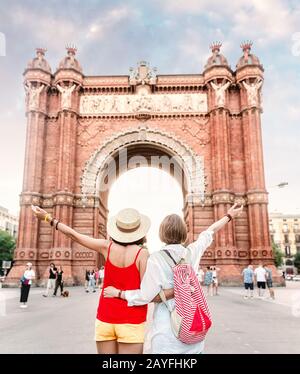 Freunde von Reisenden, die die beeindruckende Architektur des Tores Arc de Triomf in Barcelona betrachten, Stockfoto