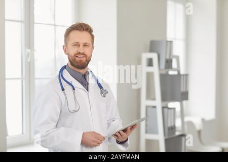 Kinderarzt steht in der weißen Klinik des Krankenhauses. Stockfoto