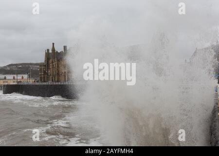 Aberystwyth, Ceredigion, Wales, Großbritannien. Februar 2020. Britische Wetterlage: Die Seeverteidigung entlang der Küstenstadt Aberystwyth nimmt eine weitere Schande, als Storm Dennis das Meer hochkreist und riesige abstürmende Wellen entlang der Promenade erzeugt. Kredit: Ian Jones/Alamy Live News Stockfoto