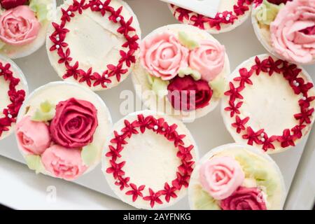 Schöne Tassenkuchen Blumen aus Buttercreme, in rot-rosa Farbe. Geeignet für Geburtstag, Jubiläum, Valentinstag und Festtage. Selektive Fokussierung Stockfoto