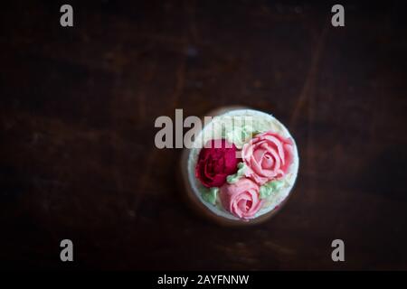 Schöne Tassenkuchen Blumen aus Buttercreme, in rot-rosa Farbe. Geeignet für Geburtstag, Jubiläum, Valentinstag und Festtage. Selektive Fokussierung Stockfoto