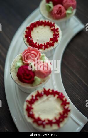Schöne Tassenkuchen Blumen aus Buttercreme, in rot-rosa Farbe. Geeignet für Geburtstag, Jubiläum, Valentinstag und Festtage. Selektive Fokussierung Stockfoto
