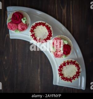 Schöne Tassenkuchen Blumen aus Buttercreme, in rot-rosa Farbe. Geeignet für Geburtstag, Jubiläum, Valentinstag und Festtage. Selektive Fokussierung Stockfoto