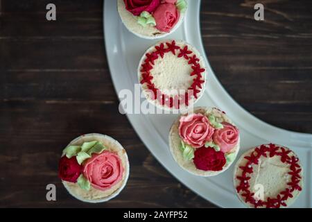 Schöne Tassenkuchen Blumen aus Buttercreme, in rot-rosa Farbe. Geeignet für Geburtstag, Jubiläum, Valentinstag und Festtage. Selektive Fokussierung Stockfoto