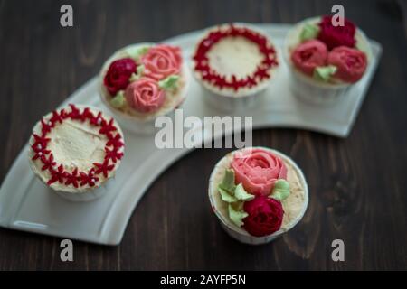 Schöne Tassenkuchen Blumen aus Buttercreme, in rot-rosa Farbe. Geeignet für Geburtstag, Jubiläum, Valentinstag und Festtage. Selektive Fokussierung Stockfoto