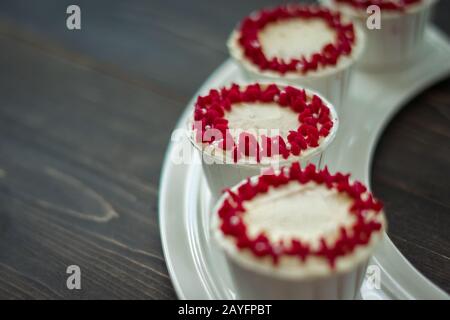 Schöne Tassenkuchen Blumen aus Buttercreme, in rot-rosa Farbe. Geeignet für Geburtstag, Jubiläum, Valentinstag und Festtage. Selektive Fokussierung Stockfoto