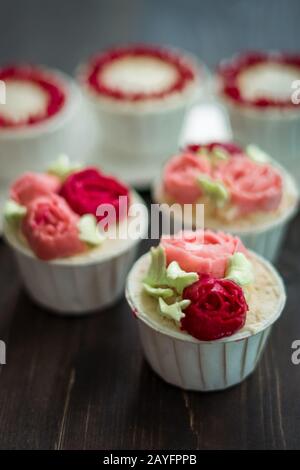 Schöne Tassenkuchen Blumen aus Buttercreme, in rot-rosa Farbe. Geeignet für Geburtstag, Jubiläum, Valentinstag und Festtage. Selektive Fokussierung Stockfoto