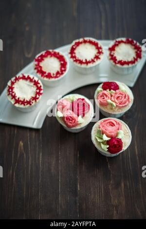 Schöne Tassenkuchen Blumen aus Buttercreme, in rot-rosa Farbe. Geeignet für Geburtstag, Jubiläum, Valentinstag und Festtage. Selektive Fokussierung Stockfoto