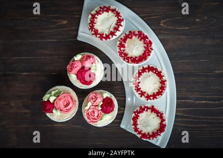 Schöne Tassenkuchen Blumen aus Buttercreme, in rot-rosa Farbe. Geeignet für Geburtstag, Jubiläum, Valentinstag und Festtage. Selektive Fokussierung Stockfoto