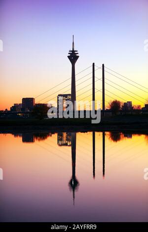 Skyline mit Stadttor, Rheinturm und Brücke Rheinkniebrücke in roter Abendbeleuchtung, Deutschland, Nordrhein-Westfalen, Niederrhein, Düsseldorf Stockfoto