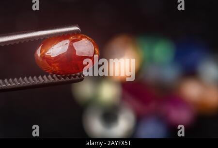 Rund geschnittene orangefarbene Sapphir-Mineralsteine mit dunklem Steinhintergrund. Stockfoto