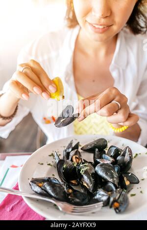 Junge Frau, Die Frisch gekochte Muscheln Isst Stockfoto