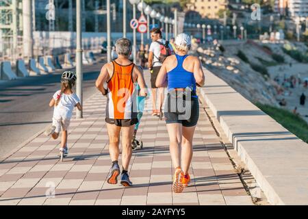 16. JULI 2018, TARRAGONA, SPANIEN: Fröhliche Gruppe von Leuten, die im Sommer am Meer laufen, Fitness- und Sportkonzept Stockfoto