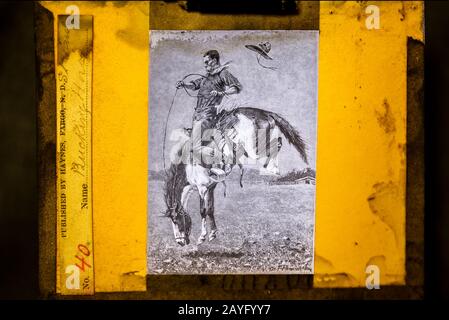 Glasscheibe mit altem Laternen und einem lithographischen Aufdruck mit dem Titel "Bucking Horse". Herausgegeben von Haynes & Bros, St. Paul. Ungefähr 1880er Jahre Stockfoto