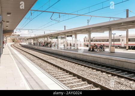 17. JULI 2018, TARRAGONA, SPANIEN: Personen, die auf den ankommenden Zug am Bahnhof warten Stockfoto