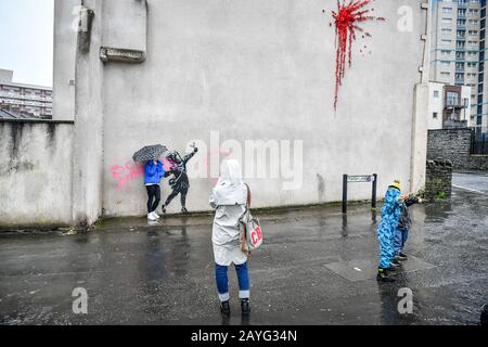 Das NOTIZBILD ENTHÄLT EIN "SWEAR WORD People"-Foto eines Banksy Kunstwerks an der Seite eines Hauses auf der Marsh Lane, Barton Hill, Bristol, das am Tag nach seiner Bestätigung am Valentinstag mit rosafarbener Sprühfarbe vandalisiert wurde. Stockfoto