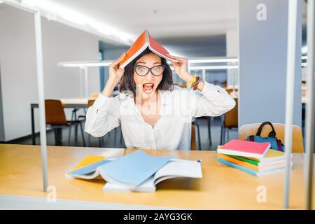 Verrückte Frau, die versucht, schwierige Prüfungen zu bestehen Stockfoto