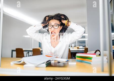 Verrückte Frau, die versucht, schwierige Prüfungen zu bestehen Stockfoto