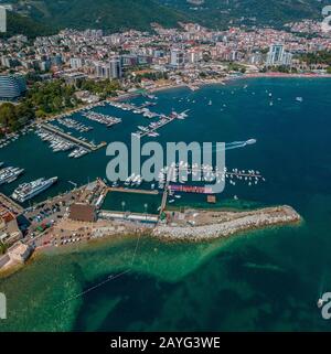 Luftaufnahme der Boote, die am Hafen von Budva, Montenegro, festgemacht wurden. Modernes Budva im Hintergrund. Strände und transparentes Meer. Urlaub und Tourismus Stockfoto