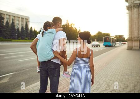 Glücklich lächelnde Familie zu Fuß auf der Straße. Stockfoto