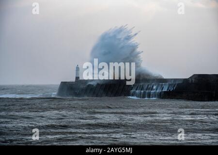 Große Sturmwellen brechen während Storm Ciara über den Porthcawl Pier Stockfoto