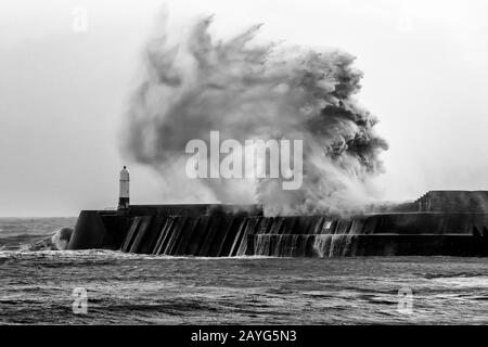 Black and White Wave krachend über Porthcawl Pier während Storm Ciara Stockfoto