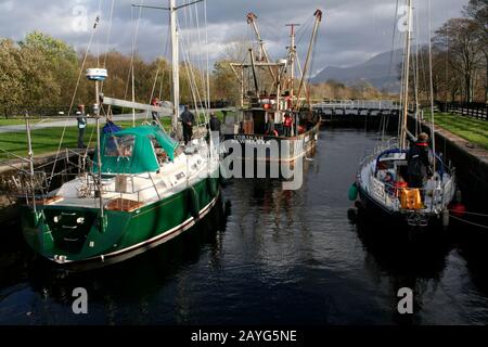 Fischerboot und Segelyachten in der Schleuse, die den Kanal von Corpach in der Nähe von Fort William, Schottland, hinauf führen Stockfoto