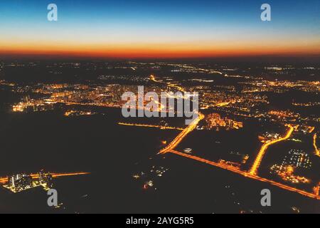 Luftaufnahme der Großstadt nachts vom Flugzeug aus. Vintage-Effekte und Filmkorn hinzugefügt. Stockfoto