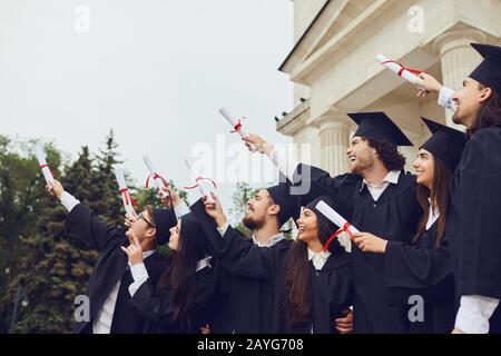Scrollt Diplome in den Händen von Absolventen. Stockfoto