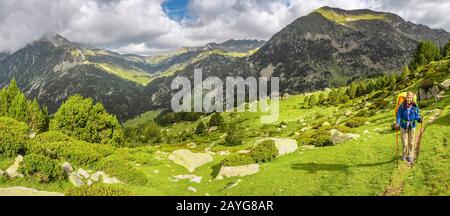 Glückliche Frau Wanderer reist in den Pyrenäen in Andorra und Spanien. Nordic Walking, Erholung und Trekking auf dem GR11-Pfad Stockfoto