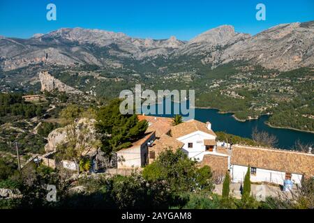 Die alte Berg-Zitadelle von Guadalest, in der Nähe von Benidorm, an der Costa Blanca, Spanien mit dem Reservoir in der Ferne Stockfoto