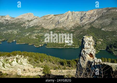 Die alte Berg-Zitadelle von Guadalest, in der Nähe von Benidorm, an der Costa Blanca, Spanien mit dem Reservoir in der Ferne Stockfoto