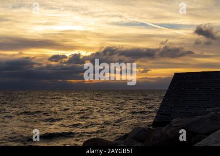 An einem windigen Frühlingsabend am Badeort Scaniabet in Malmö, Schweden, wird die Sonne untergehen Stockfoto