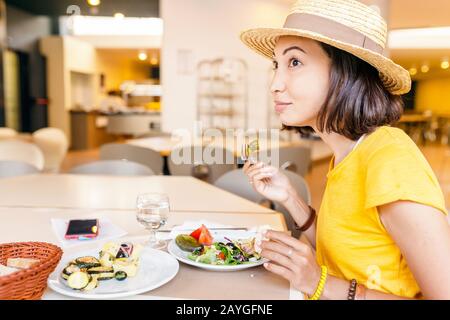 Frau, die verschiedene Snacks und Gerichte am Buffet im Hotelrestaurant auswählt und auswählt. Alles, was Sie essen können Stockfoto