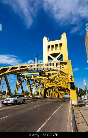 Auto, das die Gold-bemalte Tower Bridge über den Sacramento River, Sacramento, Kalifornien, USA überquert Stockfoto