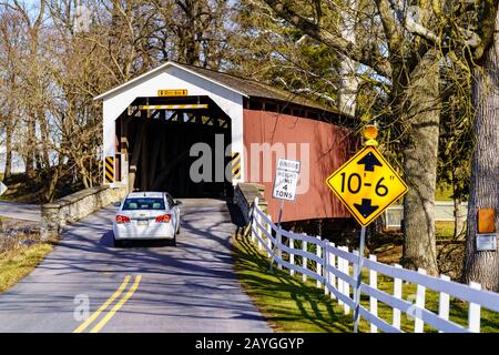 Rothsville, PA/USA - 3. Februar 2020: Erb's Covered Bridge ist eine 80 Fuß breite Strecke über den Hammer Creek im Lancaster County. Rot lackiert, die Approache Stockfoto