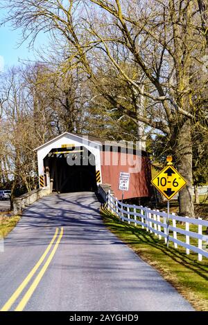 Rothsville, PA/USA - 3. Februar 2020: Erb's Covered Bridge ist eine 80 Fuß breite Strecke über den Hammer Creek im Lancaster County. Rot lackiert, die Approache Stockfoto