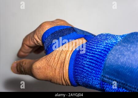 Blaues Handband an verletzter Hand oder verdrehtem Handgelenk Stockfoto