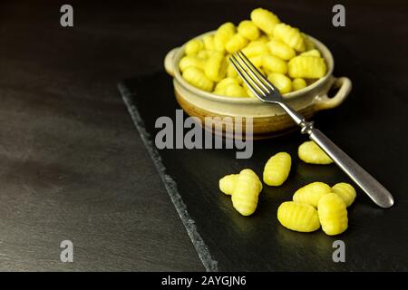 Unbehaart hausgemachte Gnocchi auf schwarzem Schieferbrett. Traditionelle Volkskost. Kartoffelgnocchi. Stockfoto