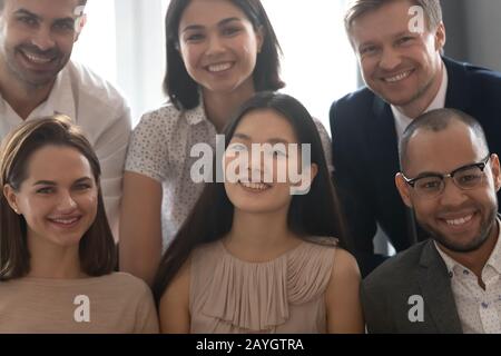 Nahaufnahmen verschiedener Kollegen, die lächeln, sehen auf die Kamera Stockfoto