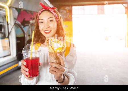 Asiatische Mädchen verkosten traditionelle griechische Fastfood-Gyros kebab im Straßencafé. Mediterrane und mittelöstliche Küche Stockfoto