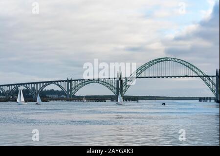 Segelboote fahren in Newports, Yaquina Bay nahe der gleichnamigen Brücke. Stockfoto